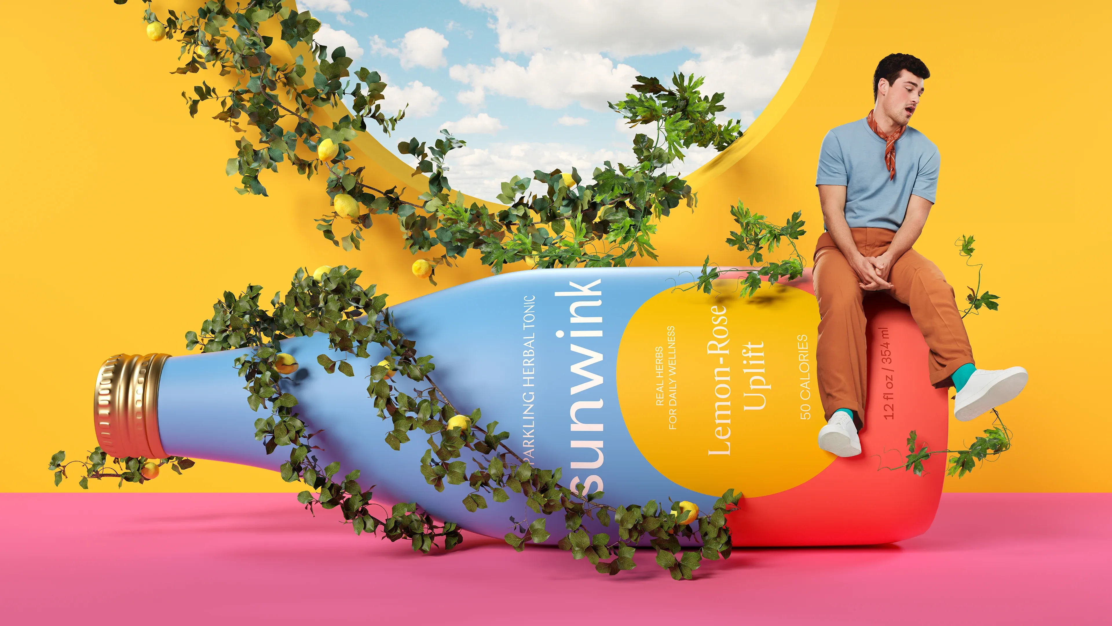 An oversized Sunwink bottle of Lemon-Rose Uplift lying on a pink floor wrapped in lemon vines, a man sitting on its base