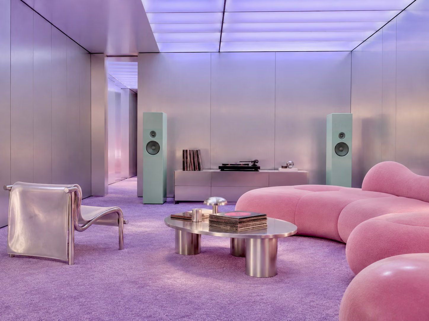The members room on Floor 3: brushed steel walls, a lilac light ceiling, a pink sofa and a record player
